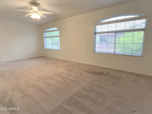 an empty room with a window and a fan