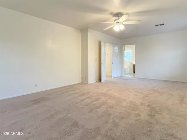 an empty room with windows and fan