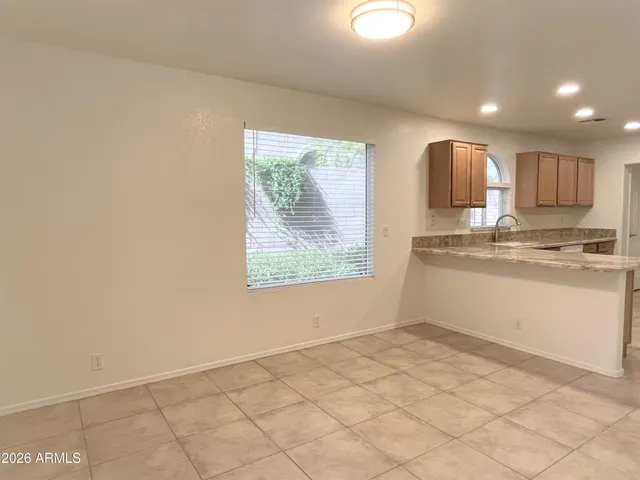 a view of kitchen with granite countertop cabinets and window