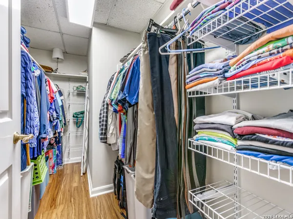 a view of walk in closet with clothes