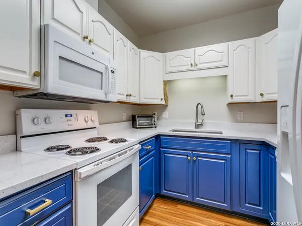 a kitchen with granite countertop a sink cabinets and stainless steel appliances