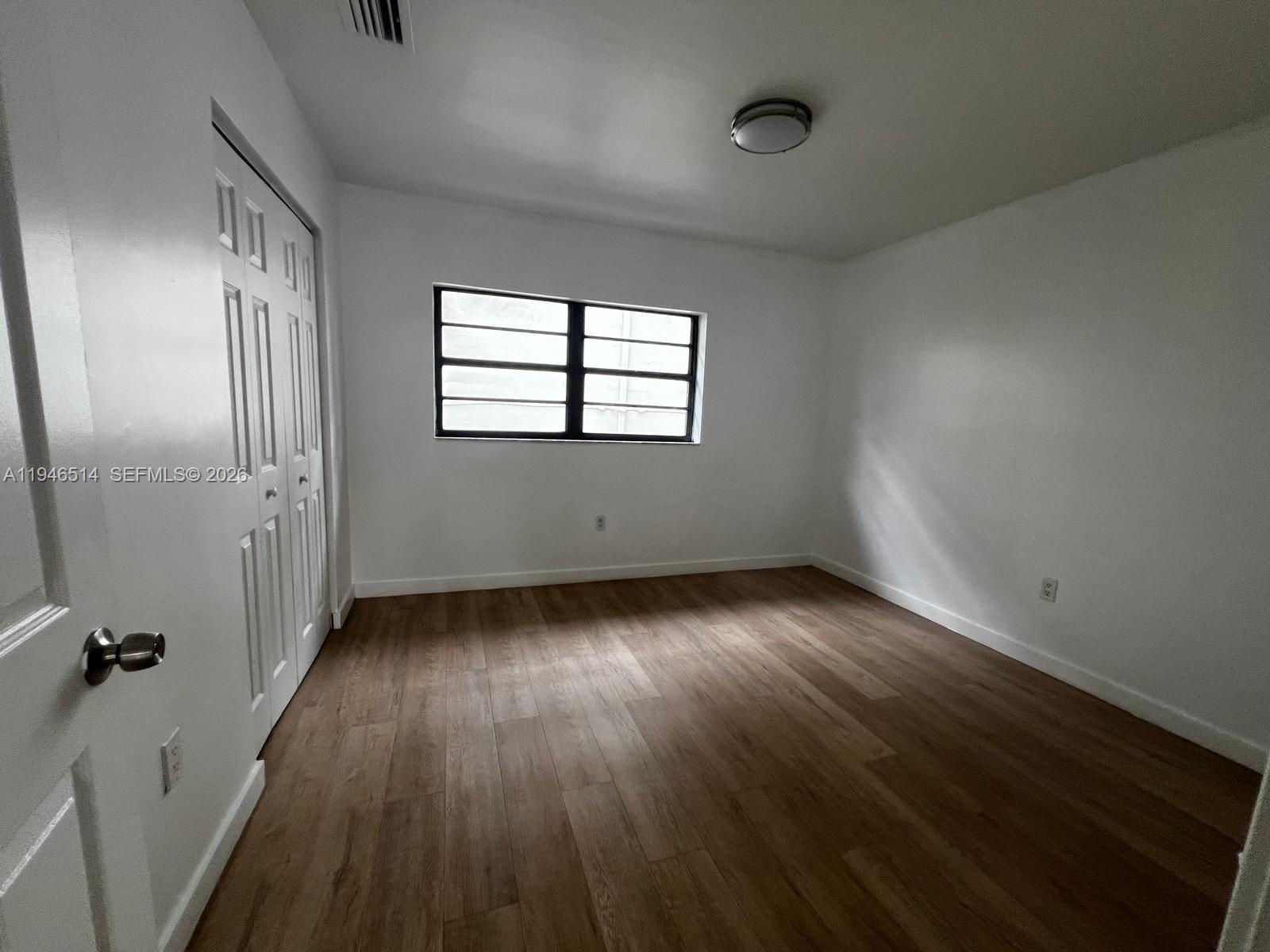 324 West 74th Place, Unit 6 Hialeah, FL 33014 - Photo 11 of 13 wooden floor in an empty room with a window