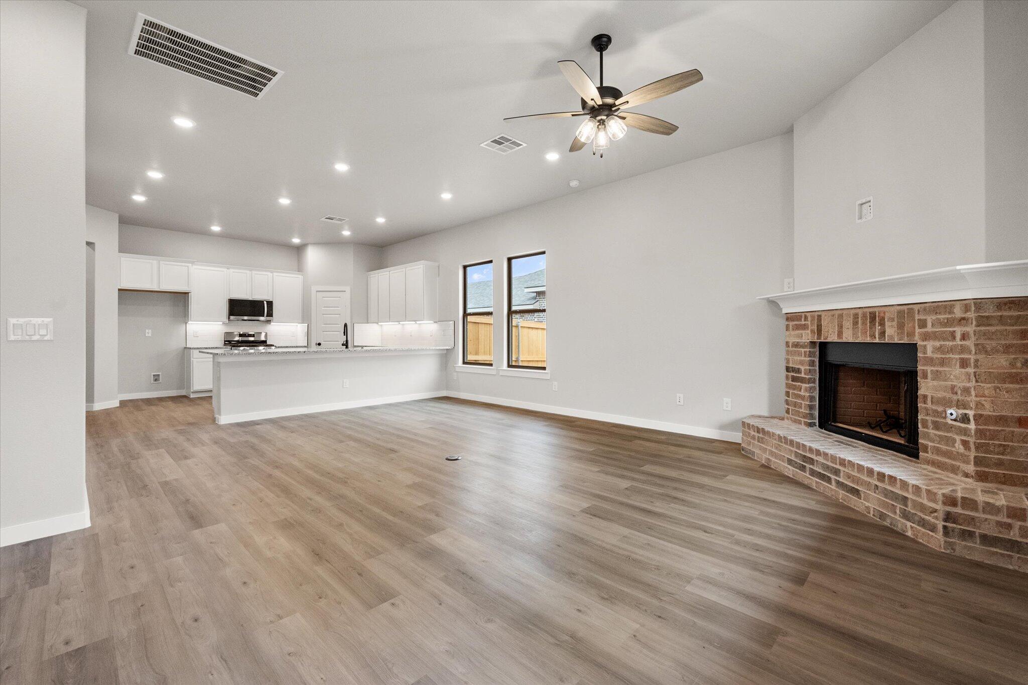 6825 54th Street Lubbock, TX 79407 - Photo 11 of 22 a view of an empty room with kitchen and fireplace