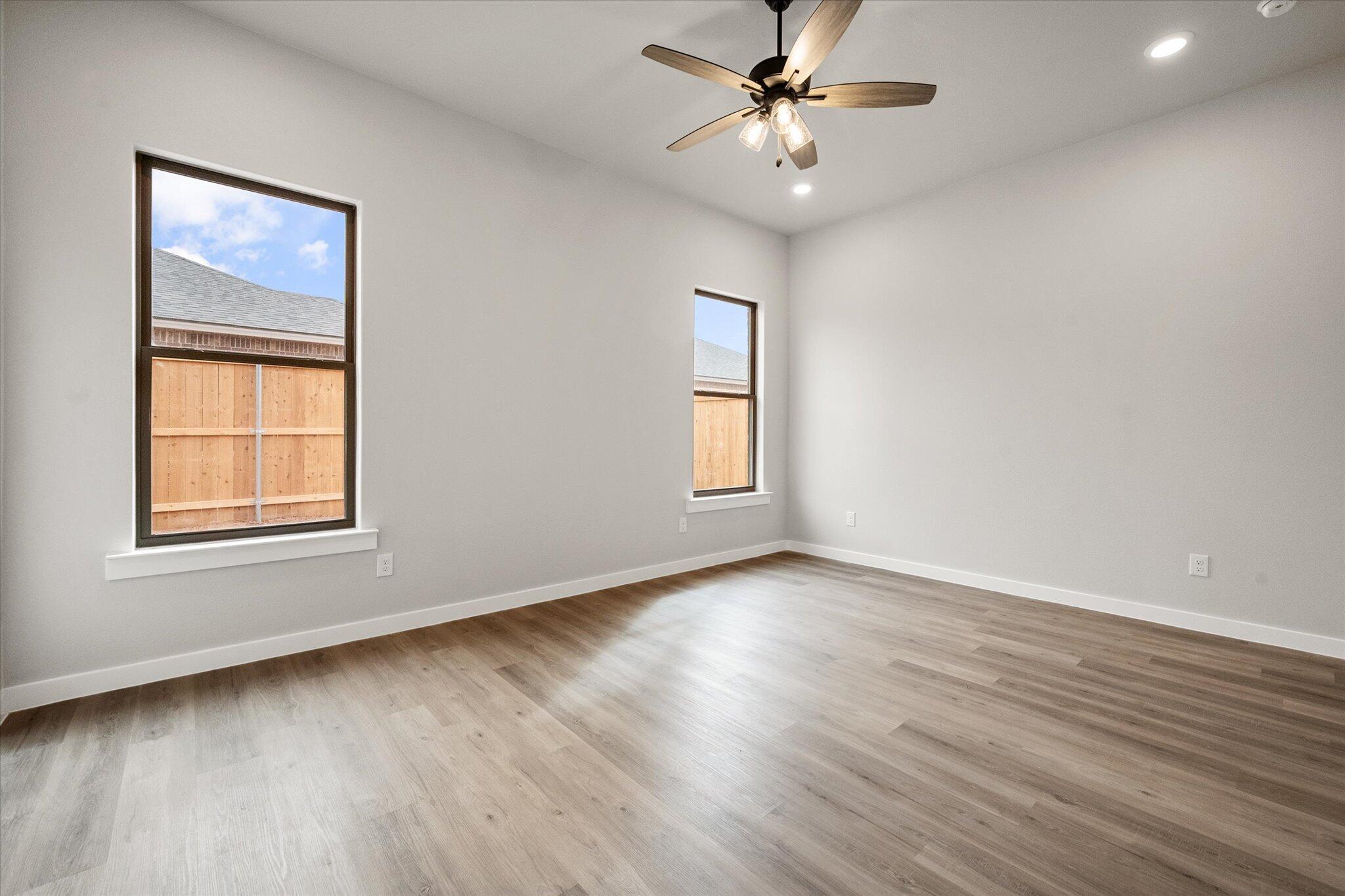 6825 54th Street Lubbock, TX 79407 - Photo 12 of 22 a view of an empty room with a window and wooden floor