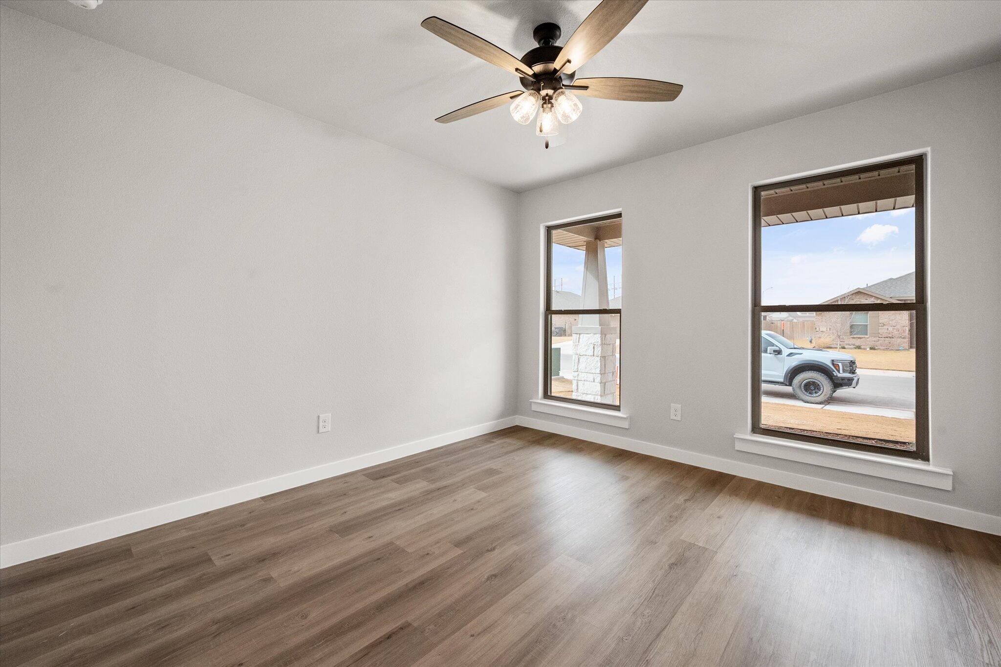 6825 54th Street Lubbock, TX 79407 - Photo 18 of 22 a view of an empty room with a window and wooden floor