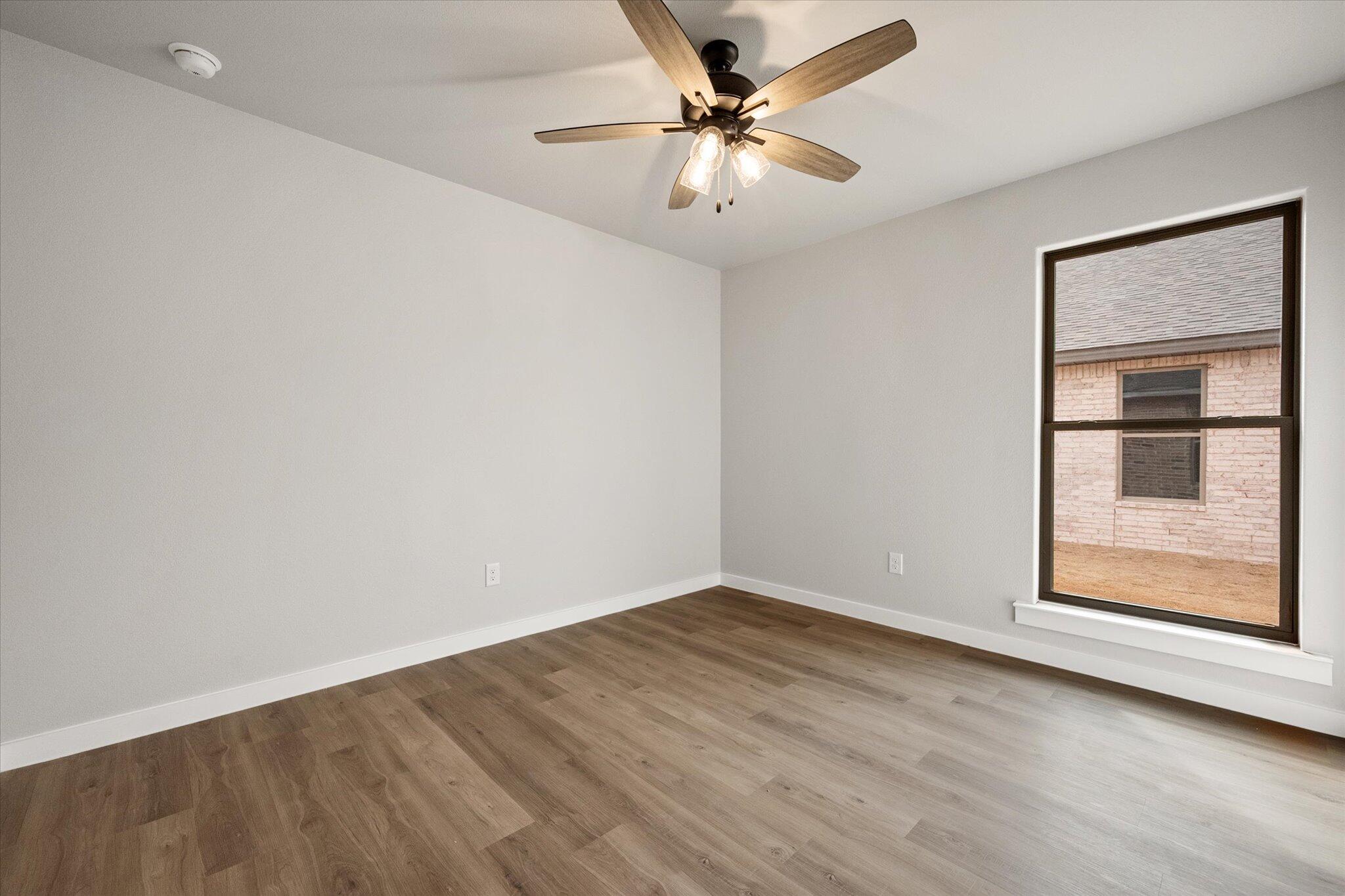 6825 54th Street Lubbock, TX 79407 - Photo 19 of 22 wooden floor in an empty room with a window