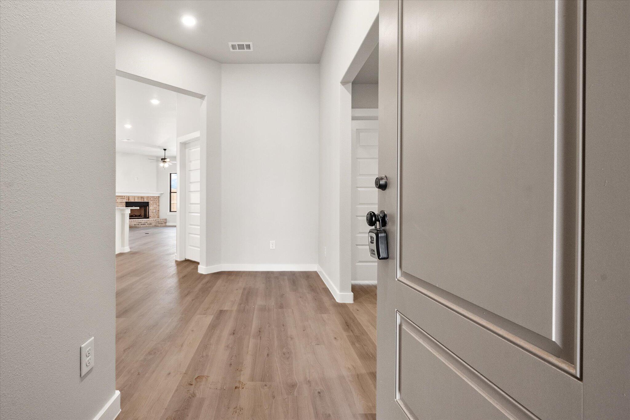 6825 54th Street Lubbock, TX 79407 - Photo 2 of 22 a view of a hallway with wooden floor and a bathroom