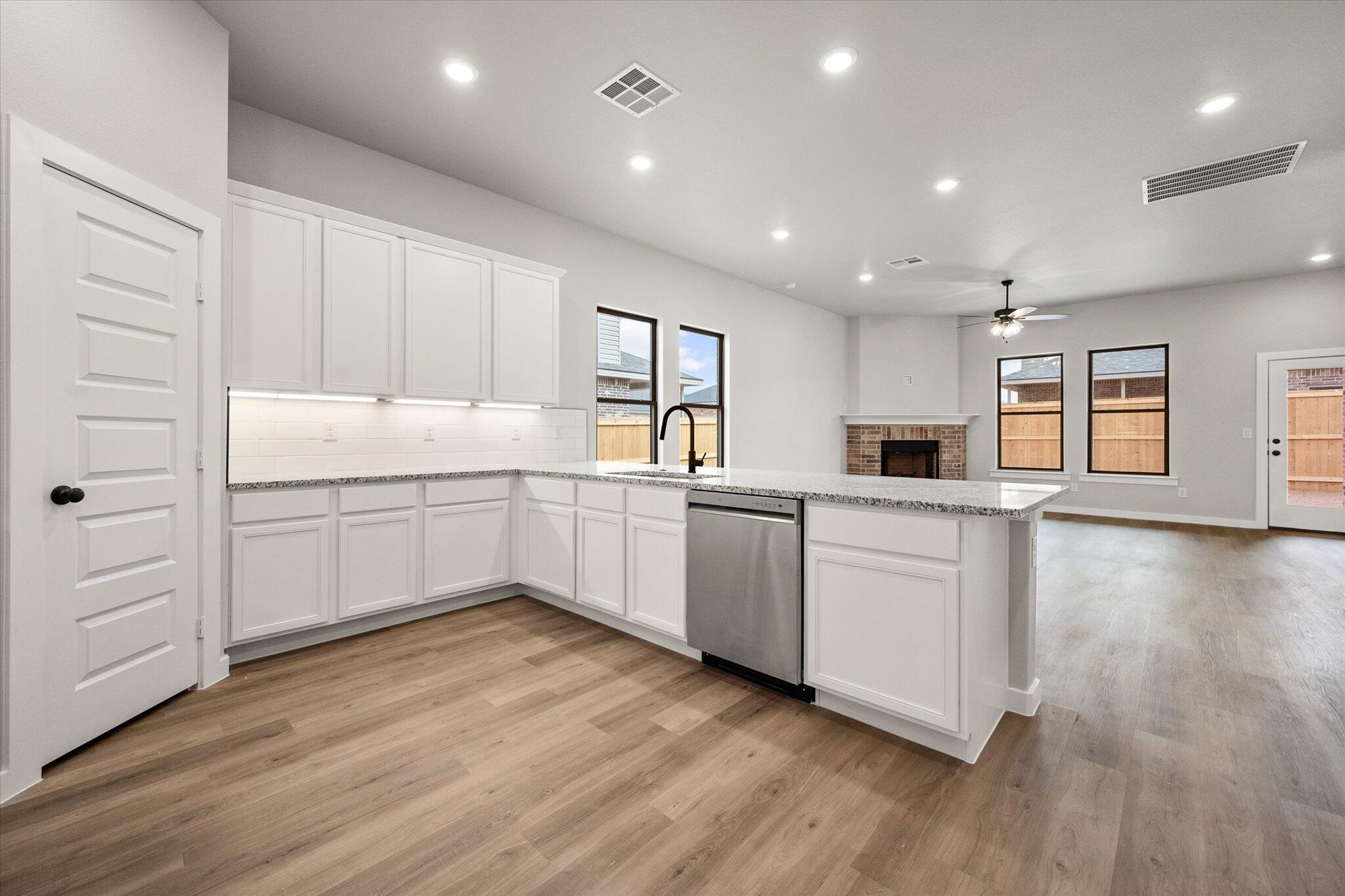 6825 54th Street Lubbock, TX 79407 - Photo 3 of 22 a kitchen with white cabinets and sink