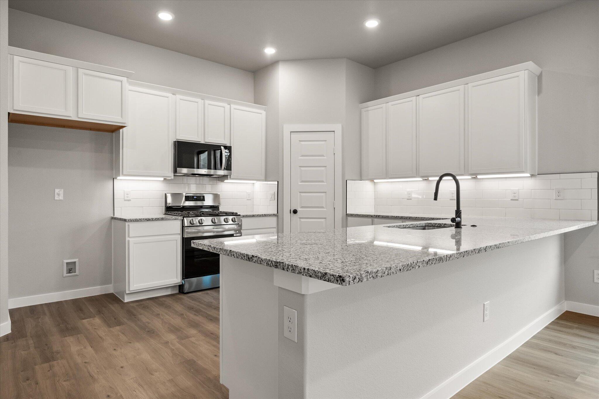 6825 54th Street Lubbock, TX 79407 - Photo 5 of 22 a kitchen with kitchen island a sink stainless steel appliances and cabinets