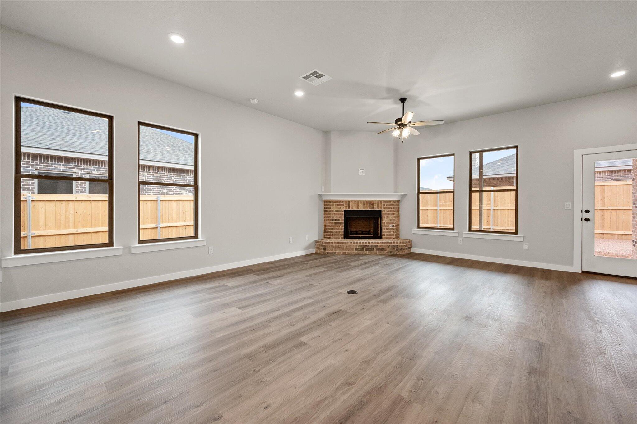 6825 54th Street Lubbock, TX 79407 - Photo 8 of 22 a view of an empty room with window and wooden floor