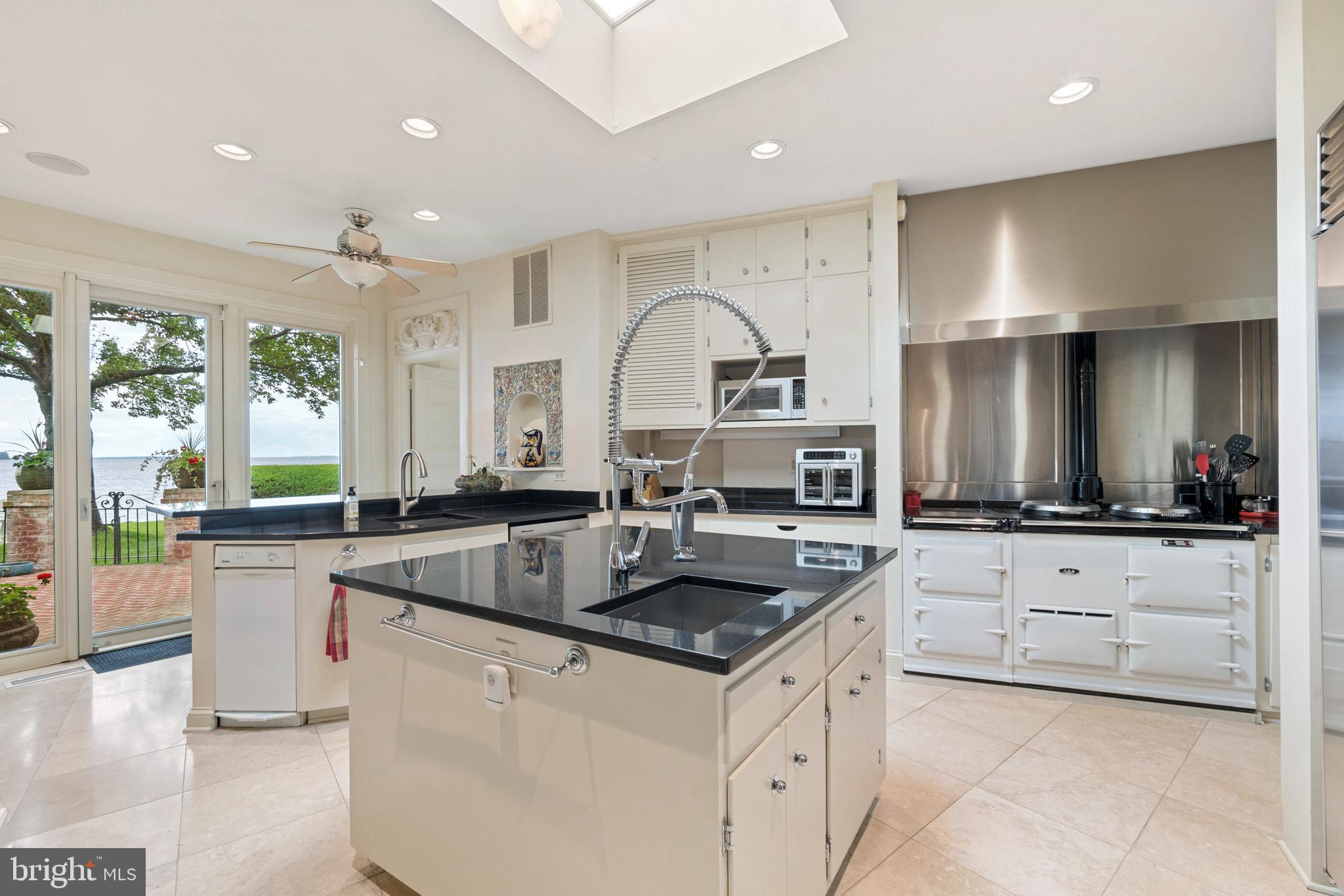9791 Pintail Place St. Michaels, MD 21663 - Photo 17 of 80 a kitchen with granite countertop a sink and white cabinets