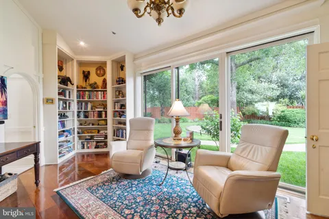 a view of a patio with couches potted plants and a large tree