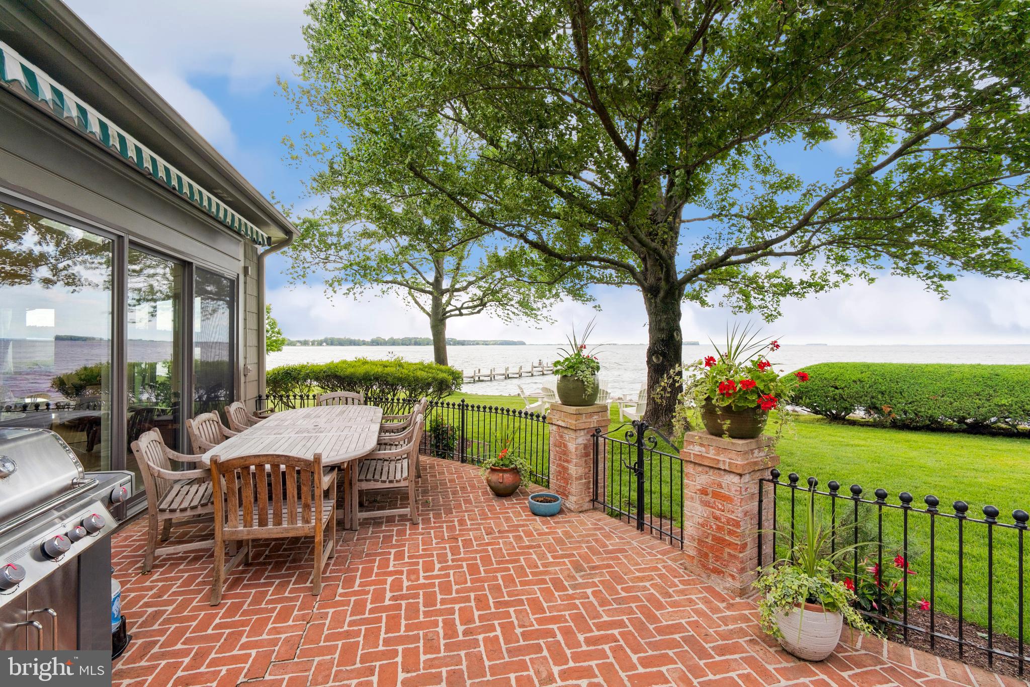 9791 Pintail Place St. Michaels, MD 21663 - Photo 42 of 80 a view of a patio with couches potted plants and a large tree