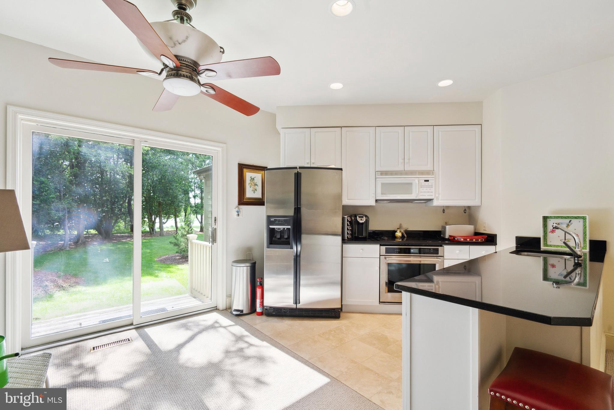 9791 Pintail Place St. Michaels, MD 21663 - Photo 45 of 80 a kitchen with kitchen island a counter top space appliances and a view of living room