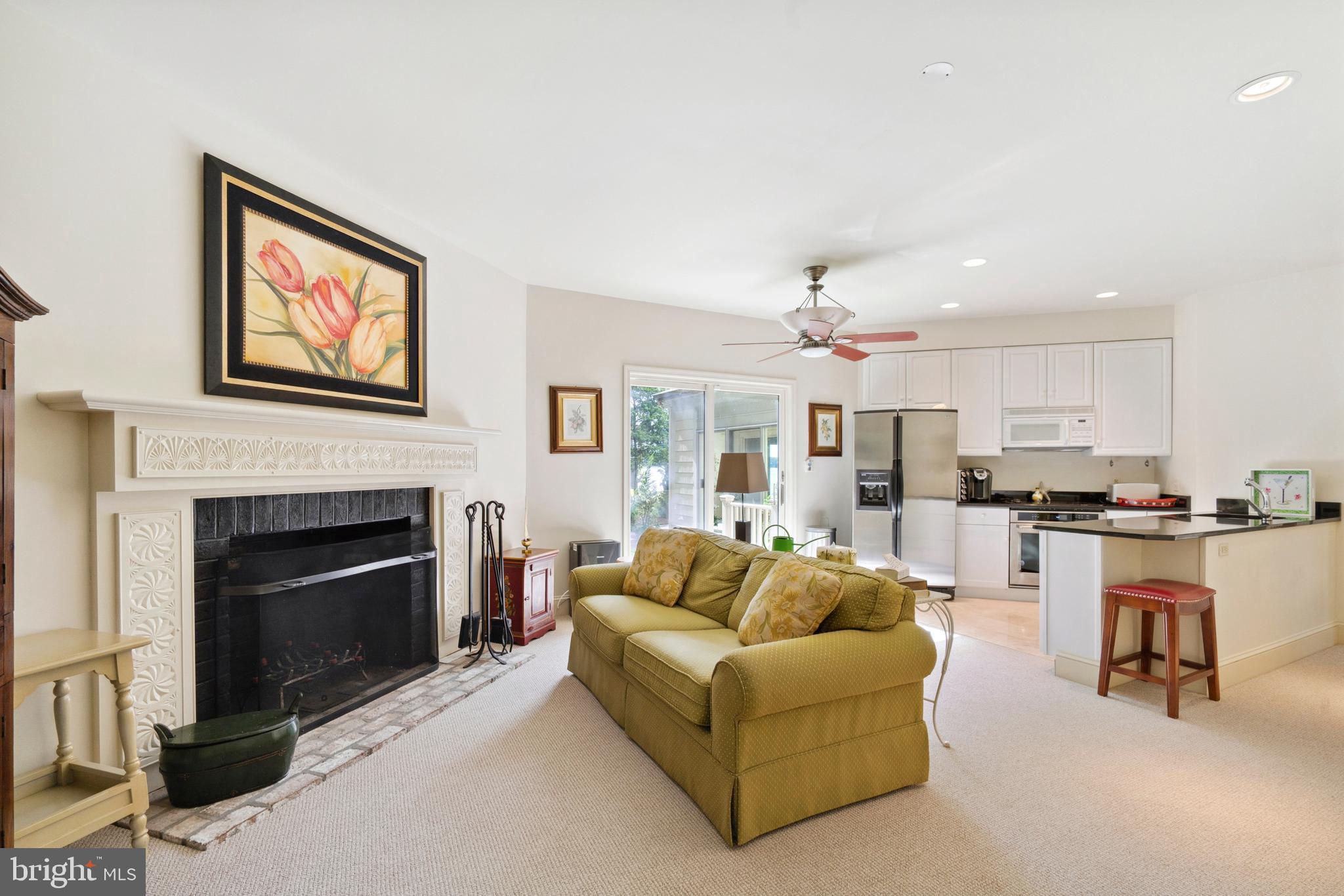 9791 Pintail Place St. Michaels, MD 21663 - Photo 47 of 80 a living room with furniture a fireplace and kitchen view