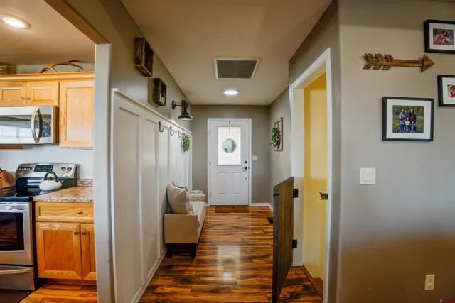 a view of a hallway with wooden floor and a livingroom