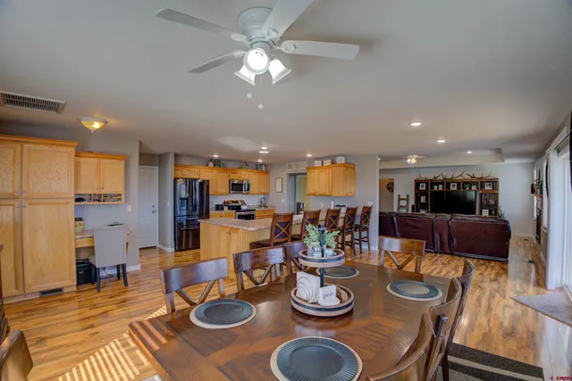 a view of a dining room and livingroom with furniture a rug a kitchen and a chandelier