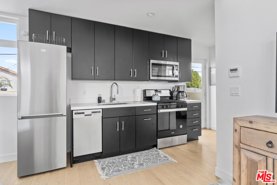 823 Flower Avenue Venice, CA 90291 - Photo 9 of 17 a kitchen with stainless steel appliances granite countertop a refrigerator stove a sink and dishwasher