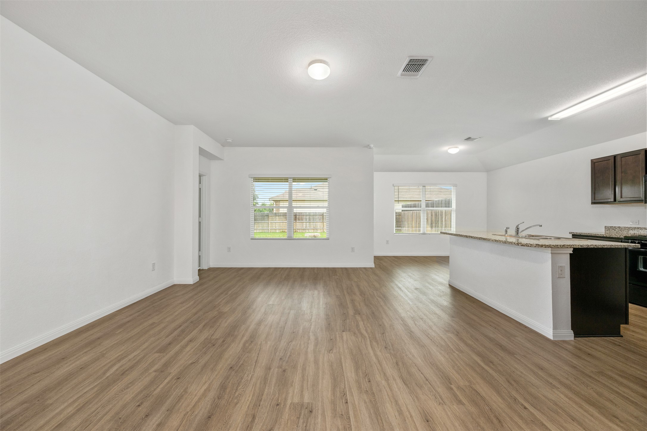 14900 Retha Pass Austin, TX 78725 - Photo 3 of 39 Expansive living area featuring wood-finish flooring, white walls, and recessed lighting