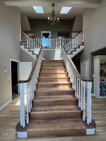 a view of staircase with lots of frames on wall and wooden floor