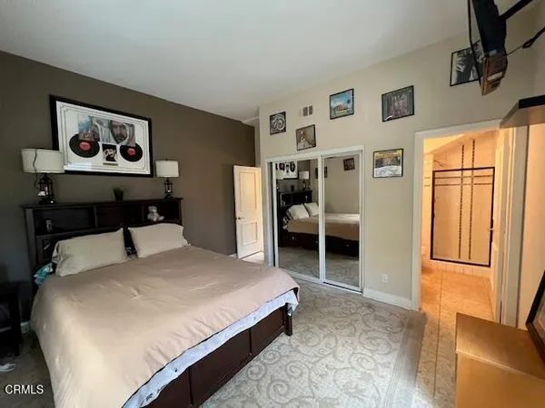a bedroom with a bed and a refrigerator