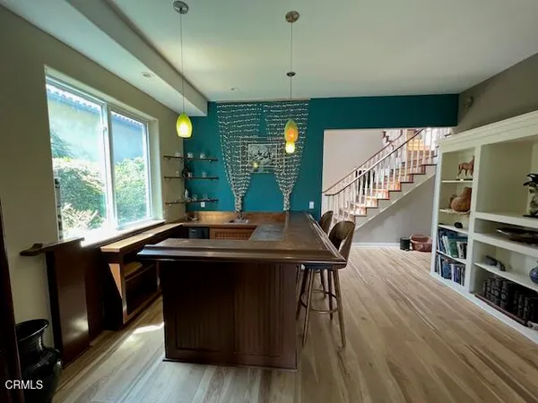 a room with furniture pool table wooden floor and windows