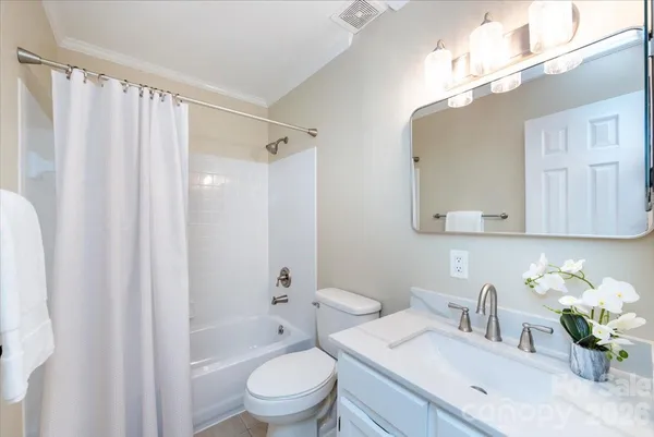 a bathroom with a granite countertop sink a toilet and shower