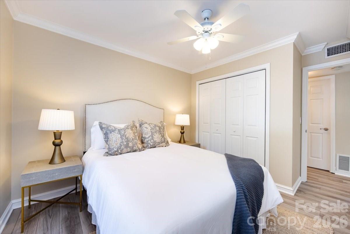 430 Queens Road, Unit 221 Charlotte, NC 28207 - Photo 17 of 21 a bedroom with a large bed and a lamp