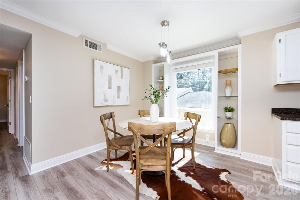 430 Queens Road, Unit 221 Charlotte, NC 28207 - Photo 6 of 21 a view of a dining room with furniture and wooden floor