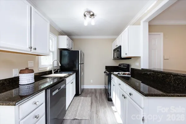 a kitchen with granite countertop a sink and a stove