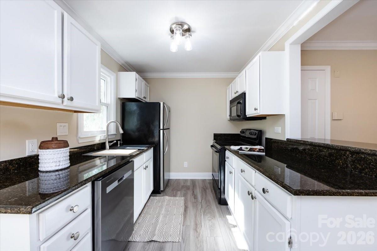 430 Queens Road, Unit 221 Charlotte, NC 28207 - Photo 9 of 21 a kitchen with granite countertop a sink and a stove