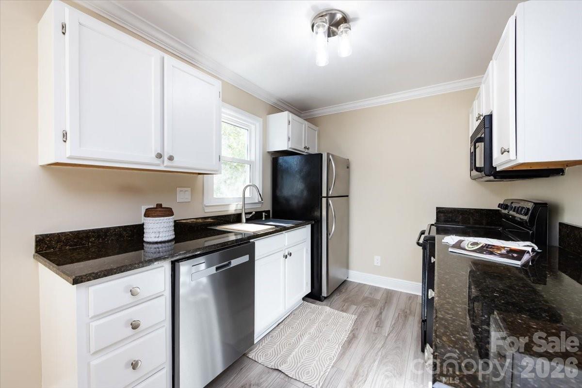 430 Queens Road, Unit 221 Charlotte, NC 28207 - Photo 10 of 21 a kitchen with granite countertop a sink a stove and refrigerator