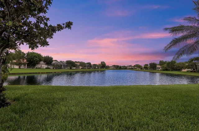 an aerial view of a house with a garden and lake view