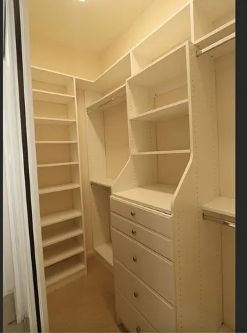 a view of walk in closet with empty racks
