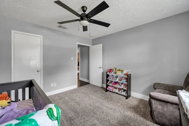 a living room with furniture and a ceiling fan