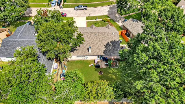 an aerial view of residential house with outdoor space and trees all around