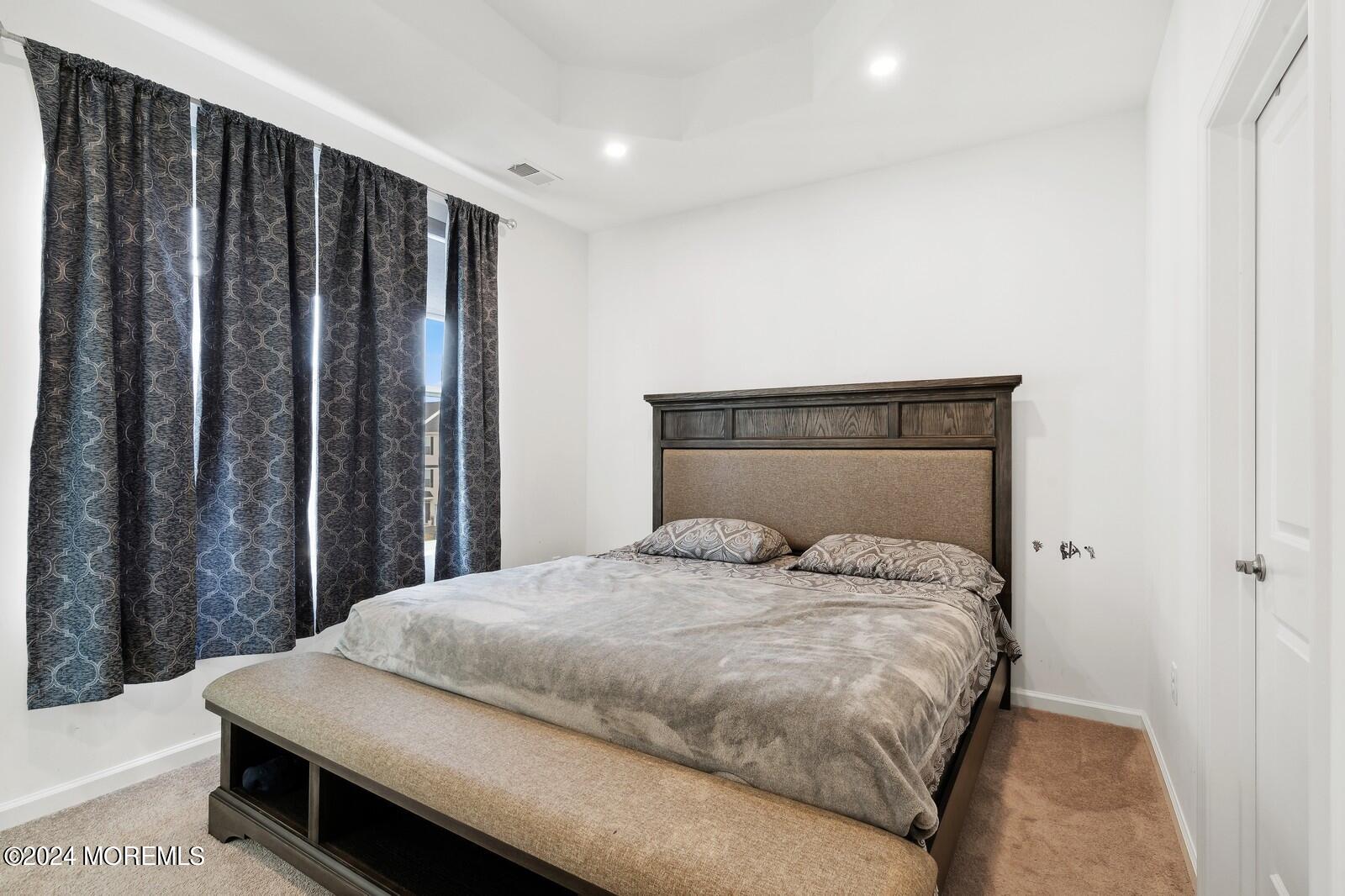 309 Revival Road Brick, NJ 08723 - Photo 13 of 37 a large bed sitting in a bedroom next to a wooden door