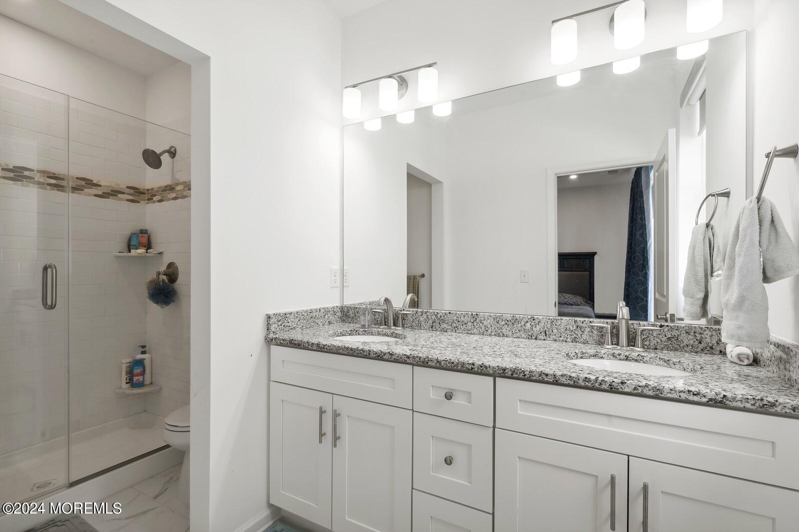 309 Revival Road Brick, NJ 08723 - Photo 15 of 37 a bathroom with a granite countertop sink two mirror and shower