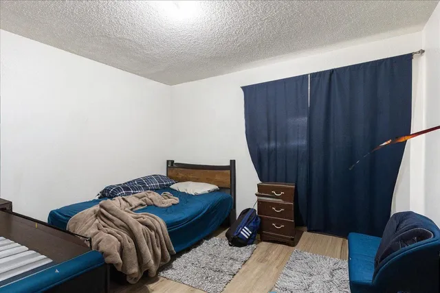 a bedroom with a bed a dresser and a mirror