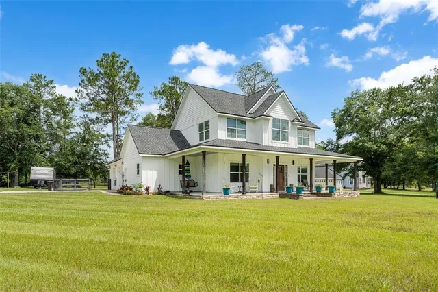 a view of a white house with a big yard and palm trees