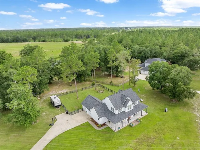 an aerial view of a house with swimming pool and a yard