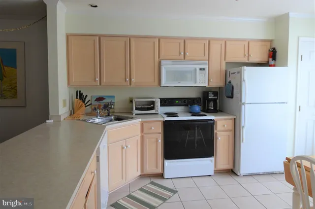 a kitchen with a refrigerator sink and cabinets