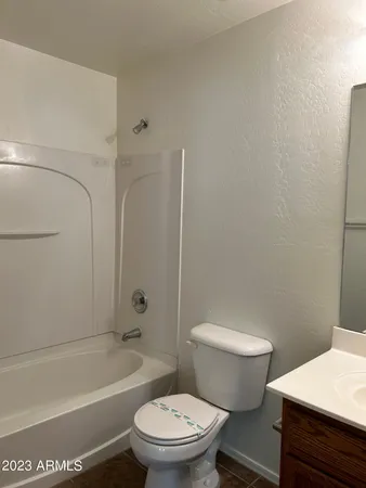 a white toilet sitting next to a bath tub