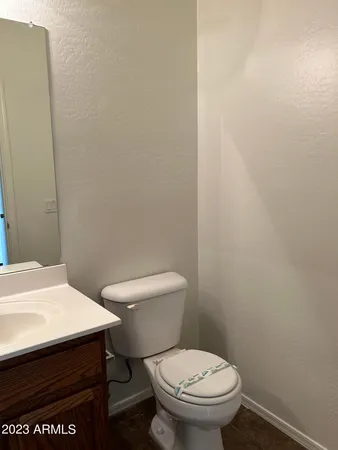 a white toilet sitting next to a white wall
