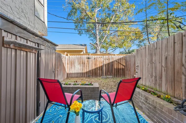 a view of a chairs in patio with wooden fence