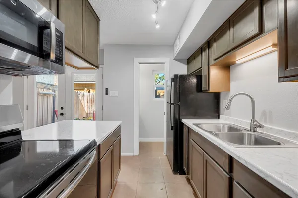 a kitchen with stainless steel appliances granite countertop a sink and a refrigerator