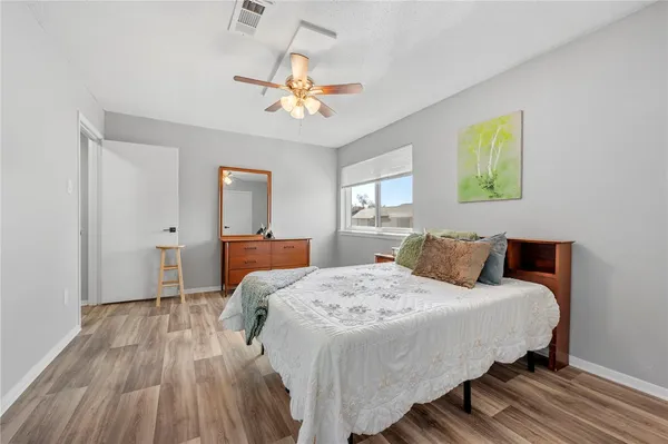 a bedroom with a bed and wooden floor