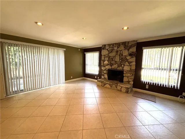 a view of an empty room with a fireplace and a window