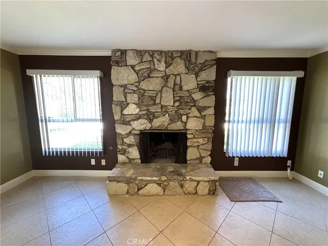 a view of a livingroom with a fireplace and large windows