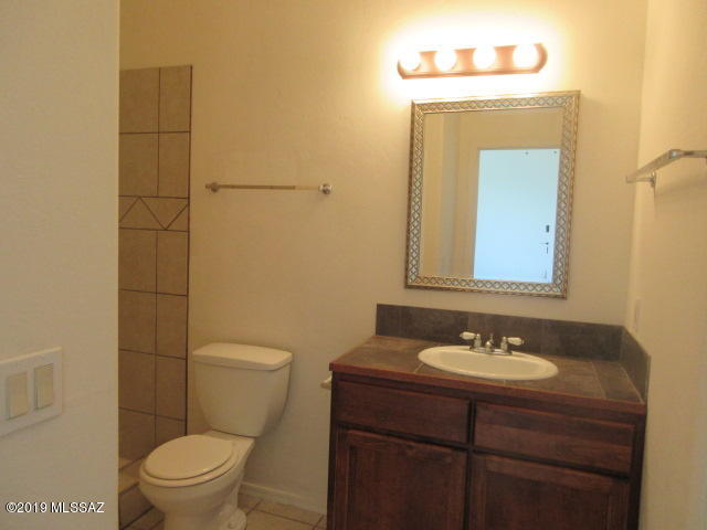 965 Circulo Tumbleweed Rio Rico, AZ 85648 - Photo 12 of 18 a bathroom with a sink a toilet and mirror